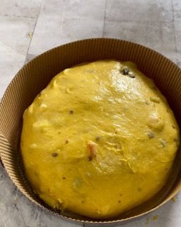 Un grande oggetto giallo si trova in una teglia di cartone su un tavolo.