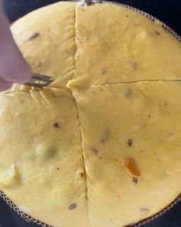 Una persona sta tagliando un pezzo di pizza con una forchetta.