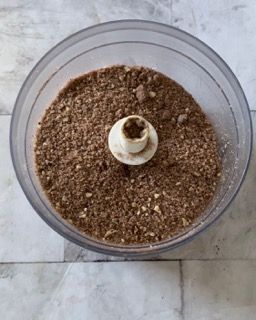 Una ciotola trasparente piena di una sostanza marrone con un buco nel mezzo