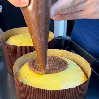 Una persona sta versando del cioccolato sopra una torta