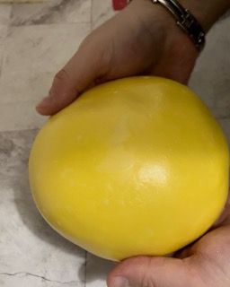 Una persona tiene in mano una grande palla gialla.