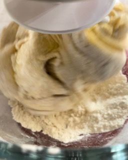 Primo piano di un mixer che mescola un impasto in una ciotola.