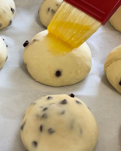 Pangoccioli lievitati vengono spennellati con uovo e latte.