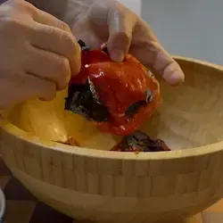 Eliminazione del picciolo e dei semi interni dai peperoni spellati.