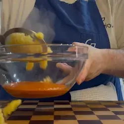 La pasta (es. rigatoni o fusilli) appena scolata e tuffata nella ciotola con la crema di peperoni.