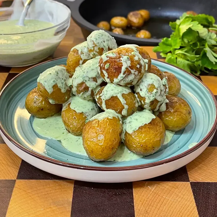 patate arrosto in padella croccanti e dorate, condite alla fine con una salsa verde alle erbe
