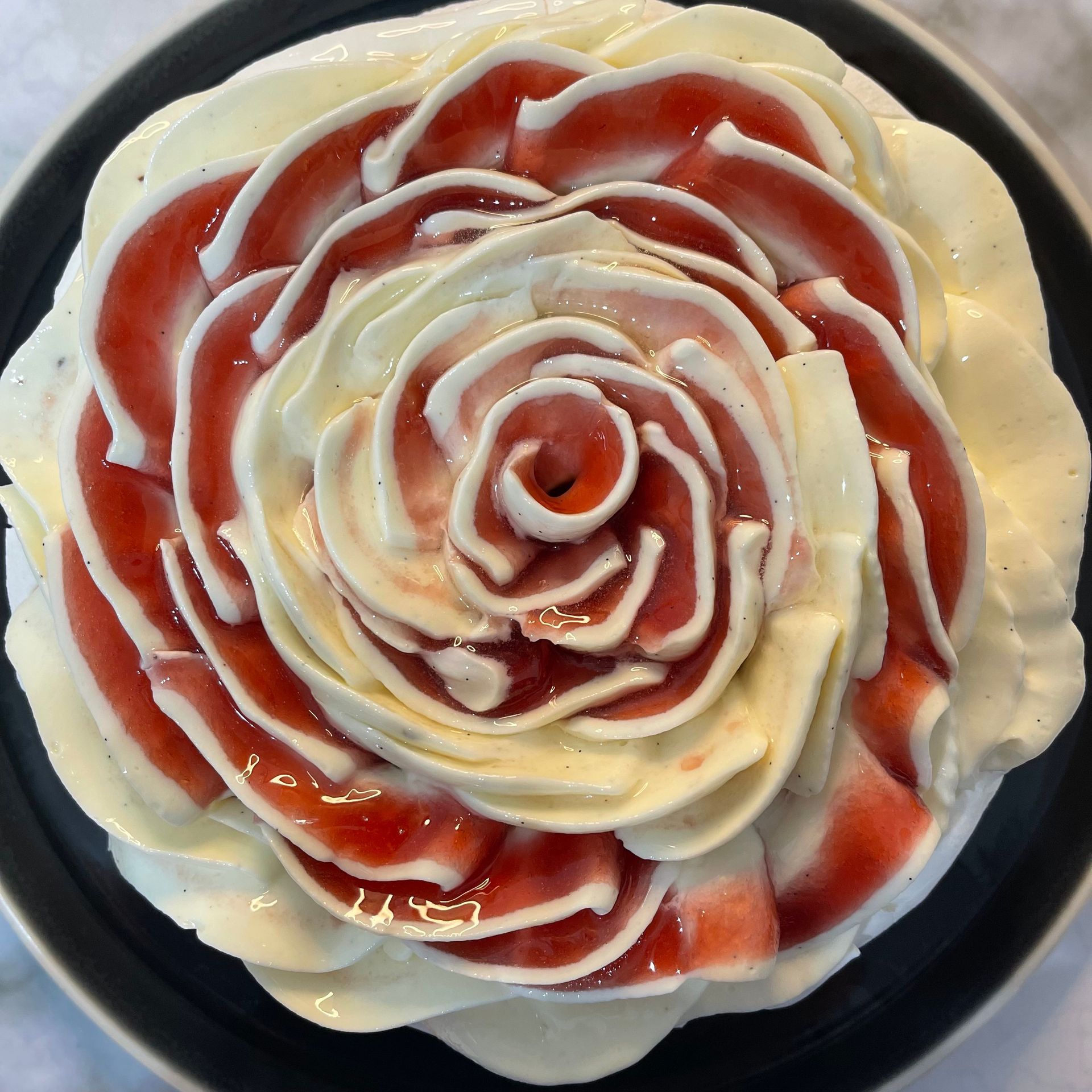 Una torta con fragole e panna montata a forma di rosa