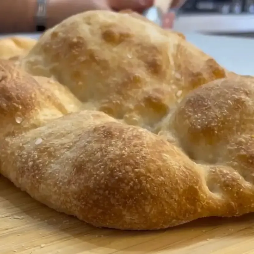 Pizza bianca romana appena sfornata, croccante e spolverata con sale grosso e olio EVO