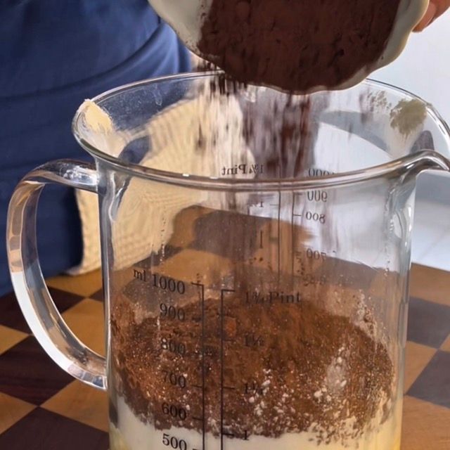 Primo piano su farina, cacao in polvere, zucchero e burro morbido.