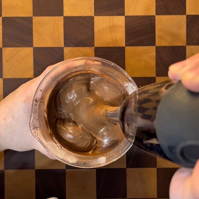 Mixer a immersione che amalgama gli ingredienti fino a creare un impasto liscio.