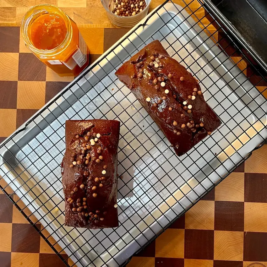 Plumcake al cioccolato soffice intero, appena sfornato su una griglia con cereali al cioccolato sopra