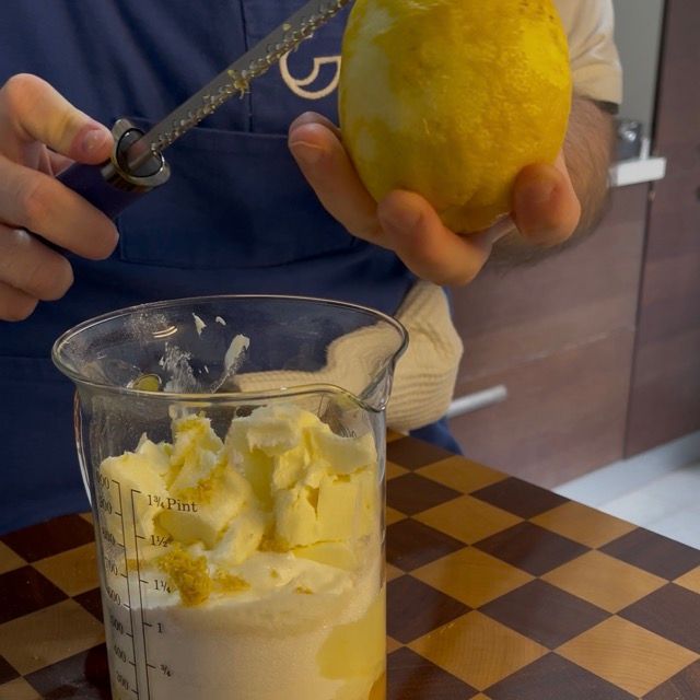 Primo piano su yogurt greco, burro morbido e scorza di limone.