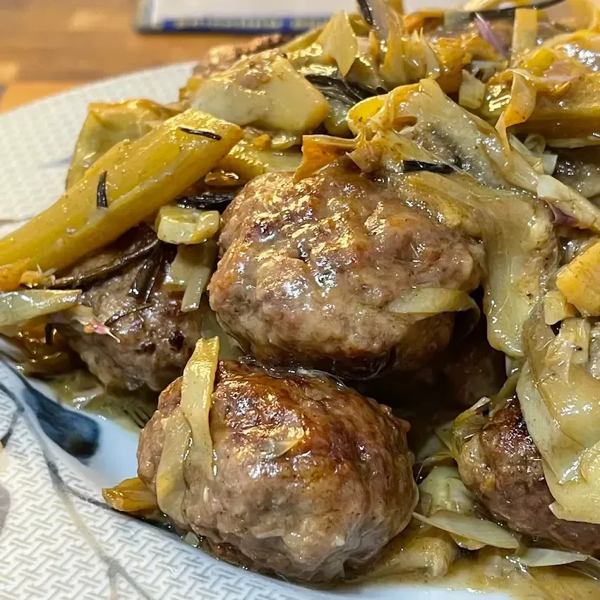 Primo piano ravvicinato di una polpette di carne tagliata a metà che mostra la consistenza soffice 