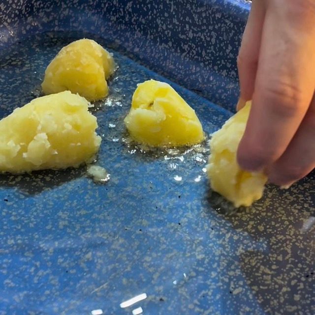 Spicchi di patate che sfrigolano nell'olio caldo all'inizio della cottura.