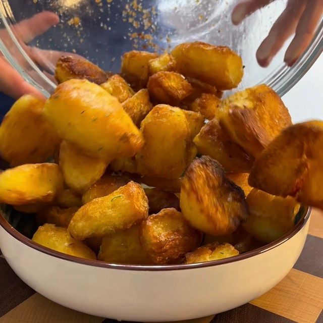 Piatto da portata con patate al forno croccantissime, fumanti e pronte da servire.