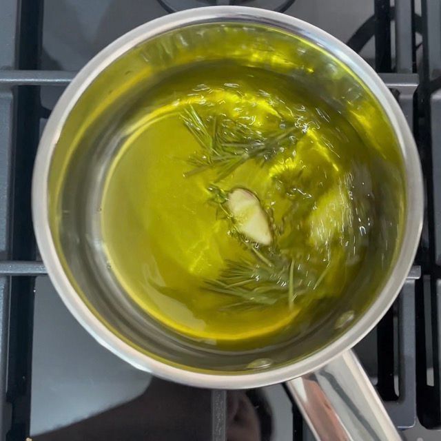 Aromi in infusione a caldo nell'olio extra vergine di oliva in un pentolino.
