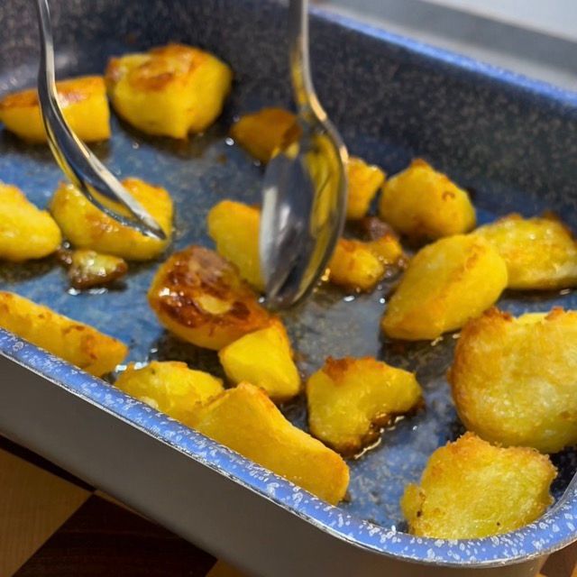 Patate al forno dorate su un lato, pronte per essere girate.
