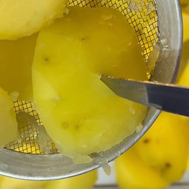 Primo piano di una patata a metà cottura, tenera ma ancora compatta.