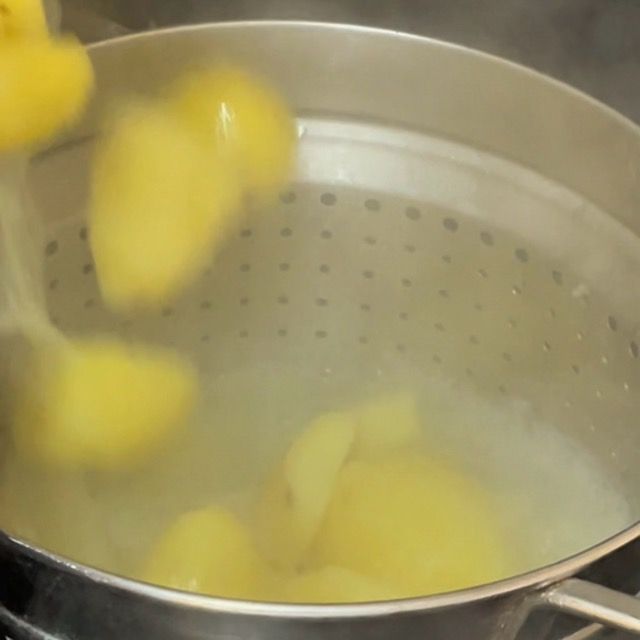 Patate bollite scolate in uno scolapasta capiente.