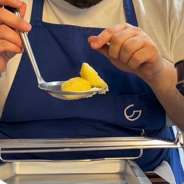 Patate pre-cotte disposte su una griglia di metallo per raffreddare.