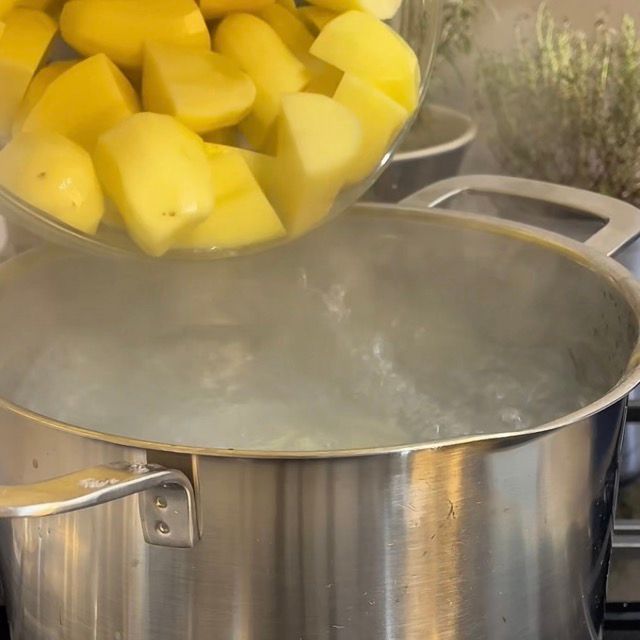 Spicchi di patate tuffati delicatamente in una pentola di acqua bollente.