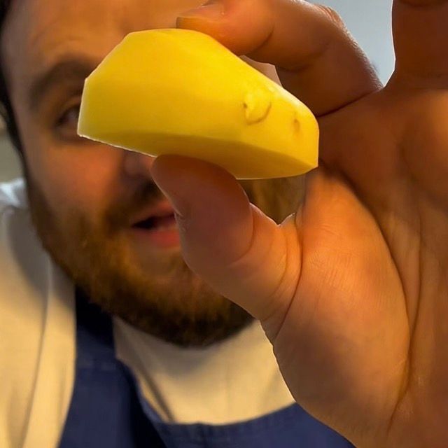 Patate tagliate in grandi spicchi regolari su un tagliere.