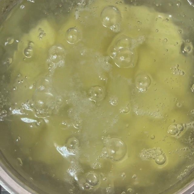 Patate che cuociono a fuoco basso durante la fase di pre-lessatura.