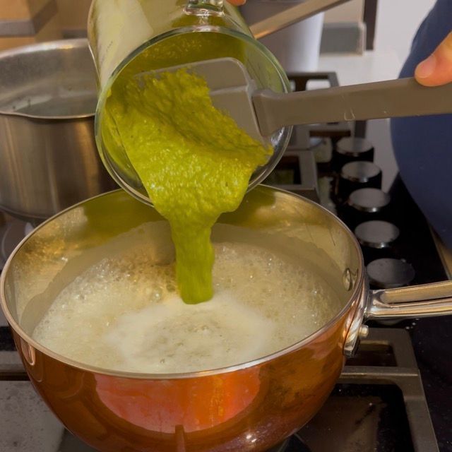 crema di asparagi viene messa nel risotto che cuoce