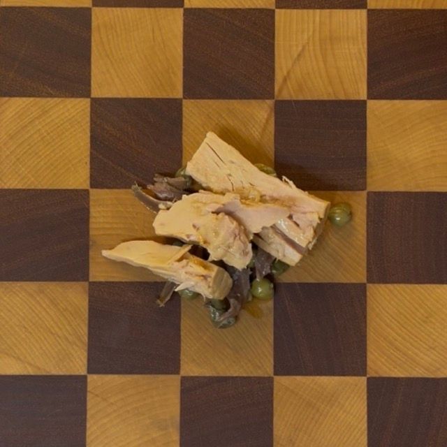 Ingredienti su un tagliere: tonno sott'olio, capperi dissalati e filetti di acciughe