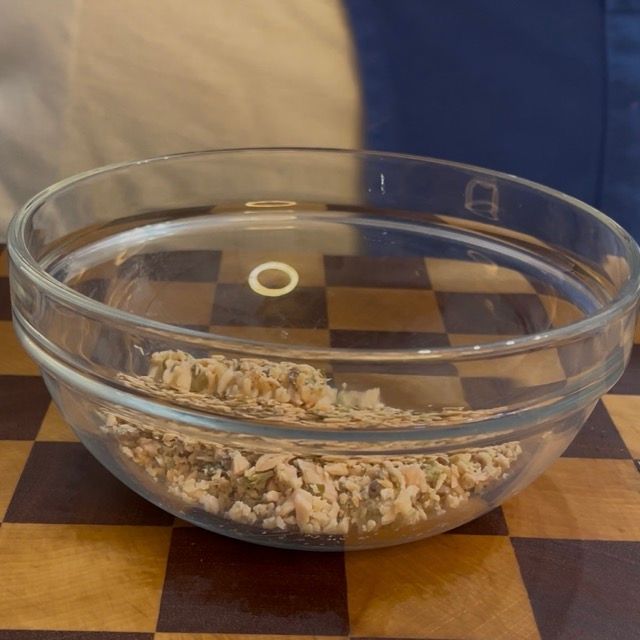 Trito di tonno, capperi e acciughe aggiunto alla maionese in una ciotola.