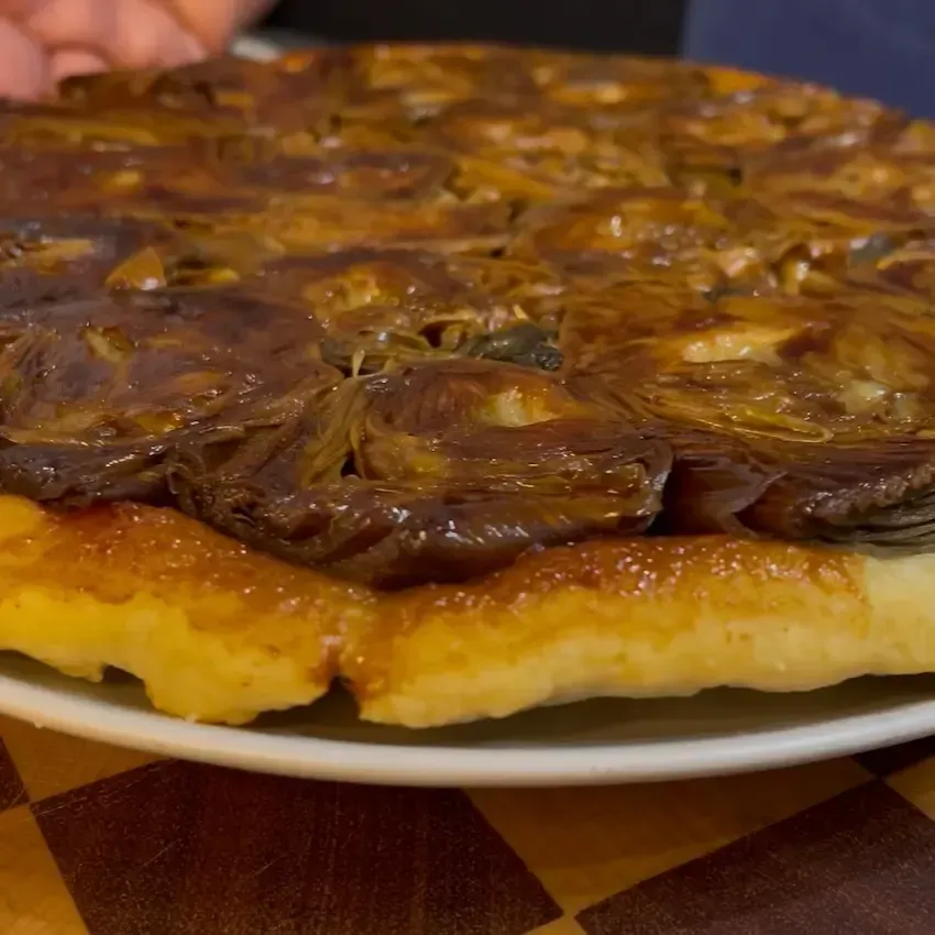 Tarte Tatin salata ai carciofi appena sfornata e rovesciata, con i carciofi perfettamente caramellat