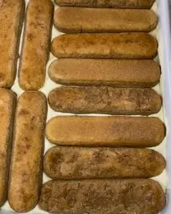 ssemblaggio del tiramisù classico con il secondo strato di crema al mascarpone spalmata sui savoiardi.