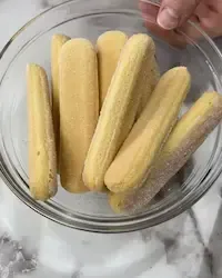 Savoiardi inzuppati velocemente nel caffè espresso per la base del tiramisù.