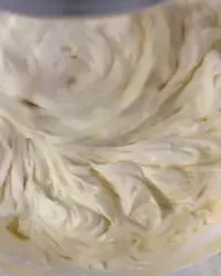 Crema al mascarpone densa e omogenea per tiramisù lavorata con una spatola in una ciotola.