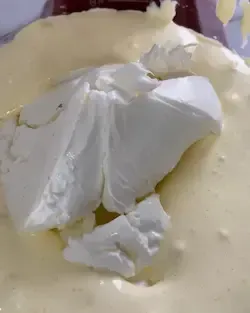 Crema al mascarpone densa e omogenea per tiramisù lavorata con una spatola in una ciotola.