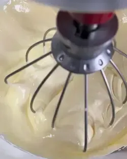 Crema al mascarpone densa e omogenea per tiramisù lavorata con una spatola in una ciotola.