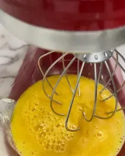 Tuorli e zucchero versati in una ciotola della planetaria