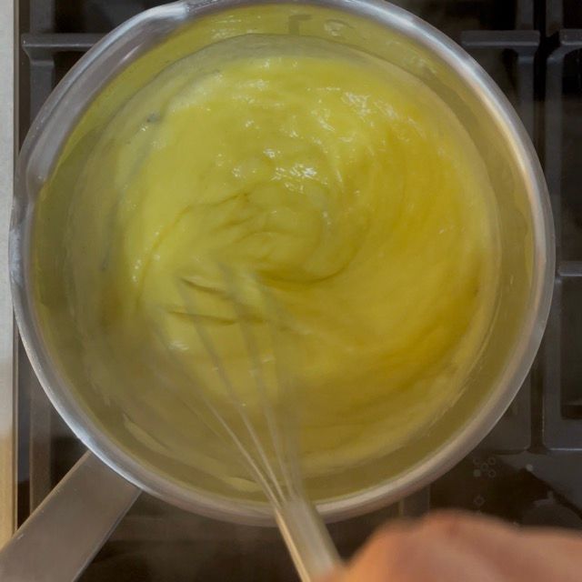 Crema cotta stesa sottile su una teglia congelata per raffreddare.