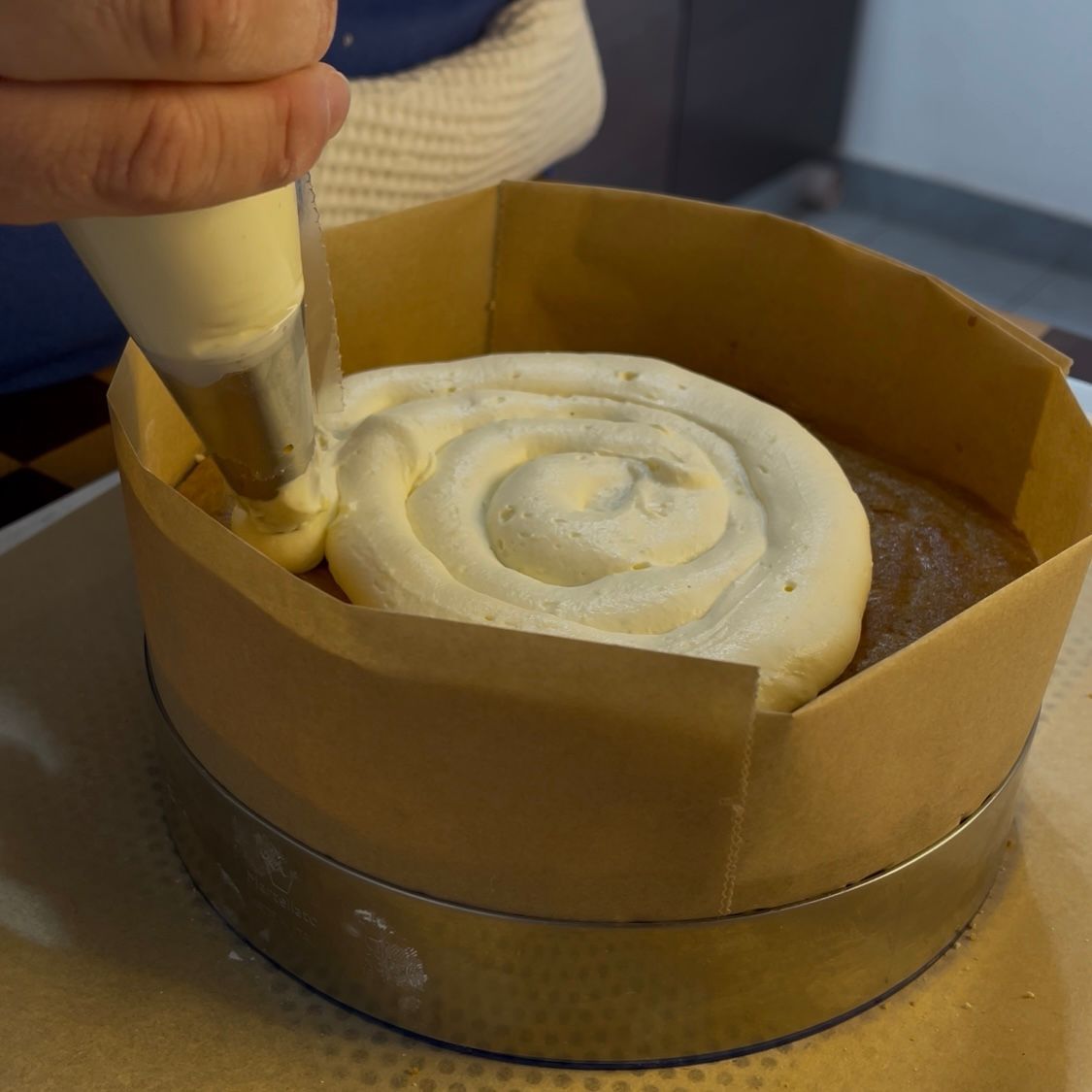 Strato uniforme di crema al mascarpone sul biscotto.