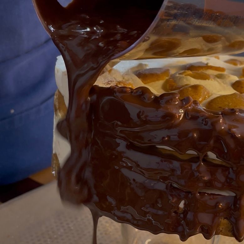 Colata di glassa rocher sui bordi della torta congelata.