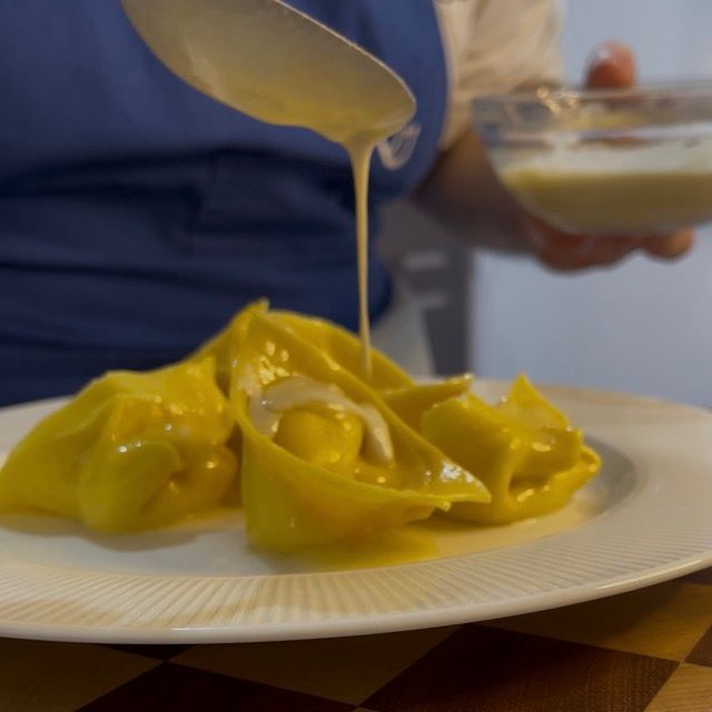 tortelloni puntarelle e acciughe vengono conditi con salsa alle acciughe