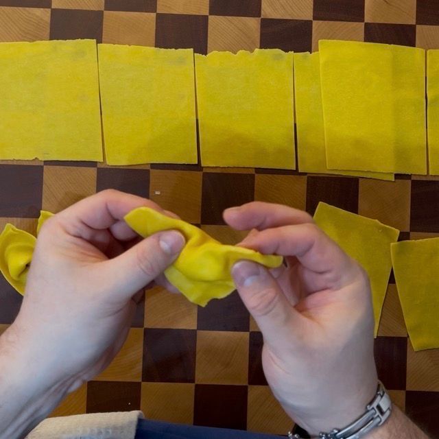 quadrati di pasta fresca all'uovo vengono chiusi come tortelloni