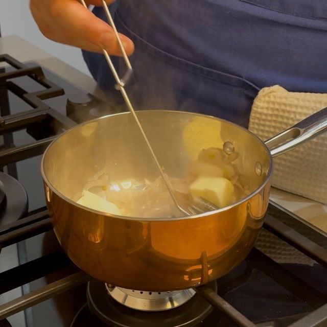 un pentolino con la riduzione mentre si aggiunge il burro freddo