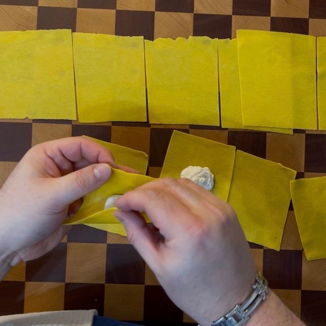 quadrati di pasta fresca all'uovo vengono chiusi come tortelloni