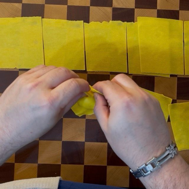 quadrati di pasta fresca all'uovo vengono chiusi come tortelloni