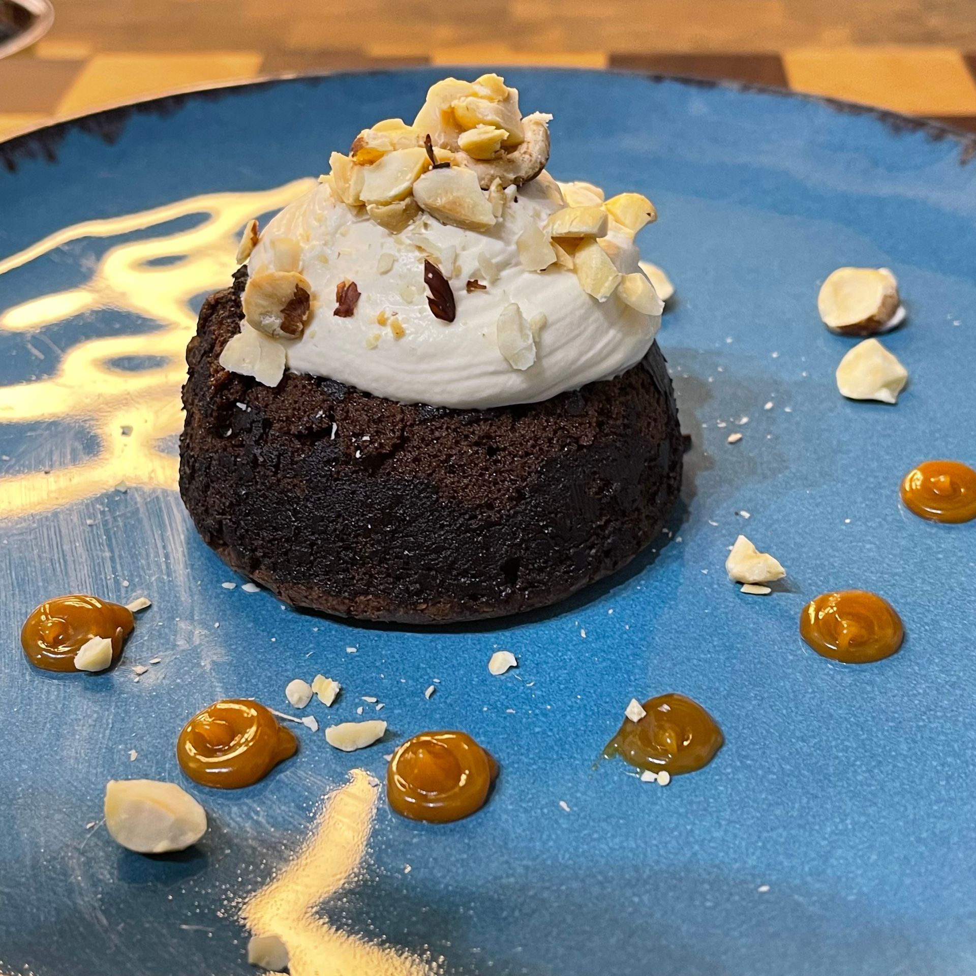 Una torta al cioccolato con panna montata e noci sopra su un piatto blu