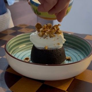 Aggiunta di nocciole caramellate per un tocco croccante al tortino al cioccolato dal cuore caldo.