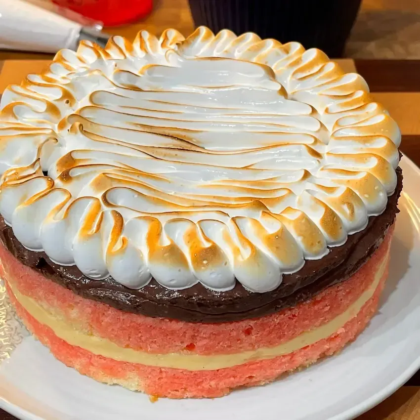 Zuppa Inglese in un vassoio che mostra gli strati colorati di crema e la copertura di meringa