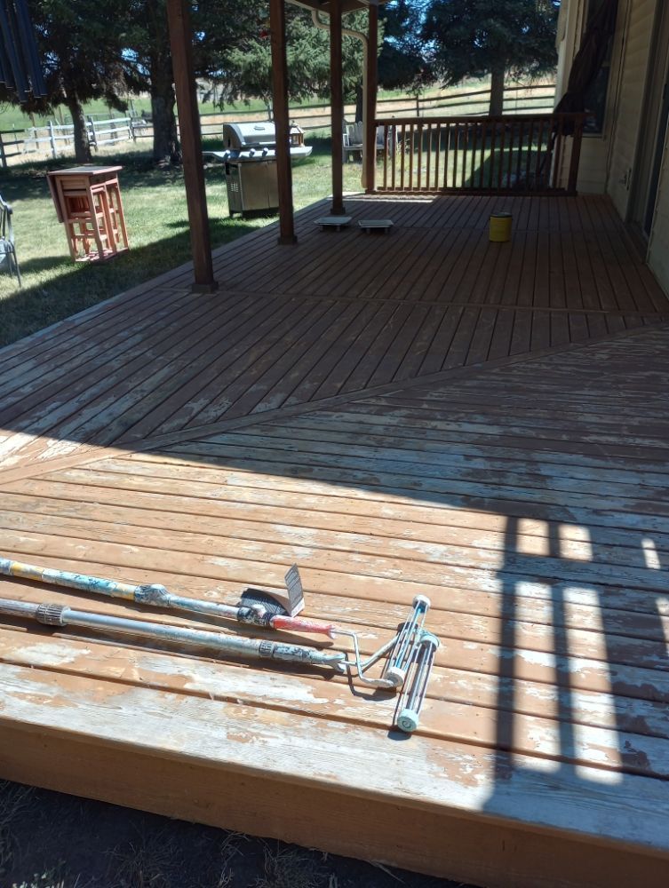 Wooden deck with peeling stain, tools laid out.