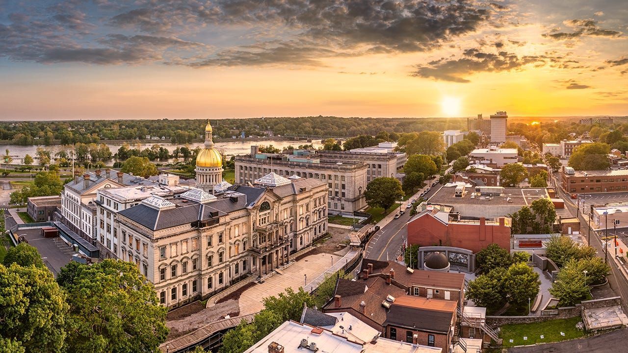 Aerial view of Harrisburg, Pennsylvania at sunset, with golden domed capitol building and Susquehanna River.